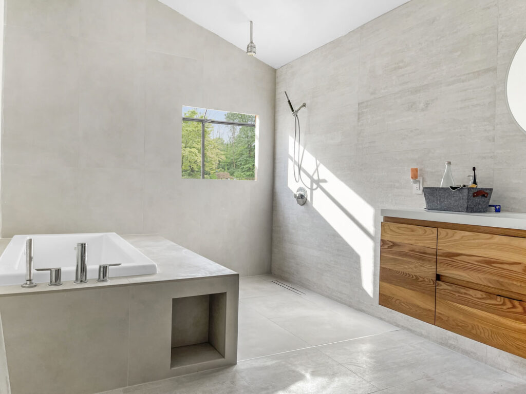 Roomy bathroom remodel with concrete and wood.