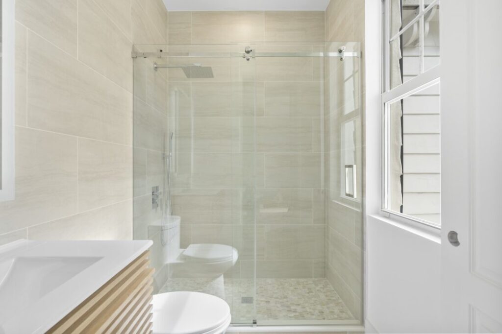 Bathroom toilet and shower with clear glass